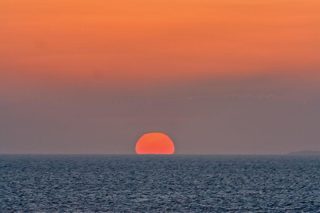 Mykonos - piękny zachód słońca nad morzem, czarter jachtów w Grecji