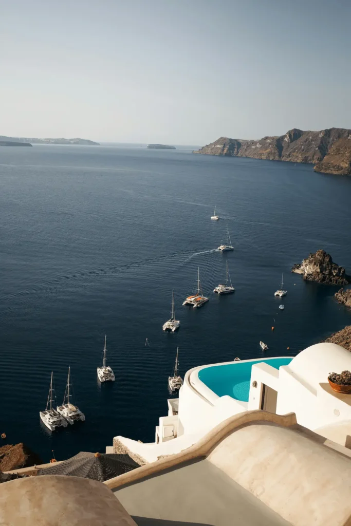 Widok na kalderę Santorini z jachtami i katamaranami zakotwiczonymi w zatoce