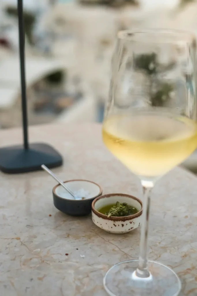 Kieliszek białego wina Assyrtiko na tarasie z widokiem na morze na Santorini