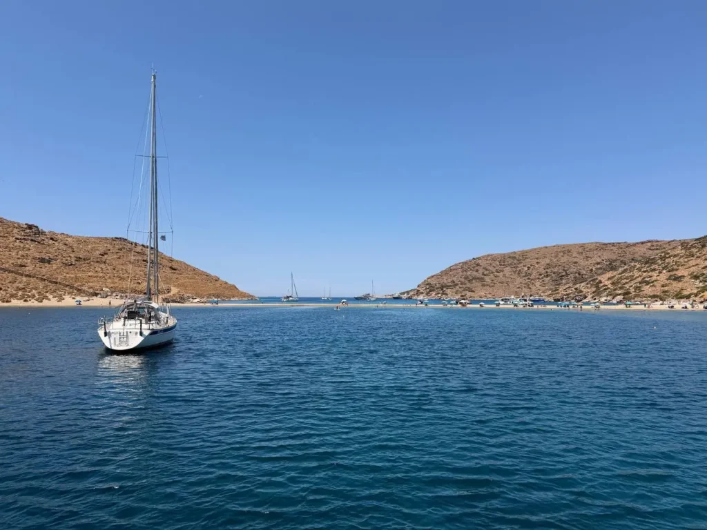 Jacht żaglowy stojący na kotwicy w spokojnej zatoce na wyspie Kythnos w Grecji.